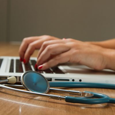 close up of laptop and stethoscope on desk