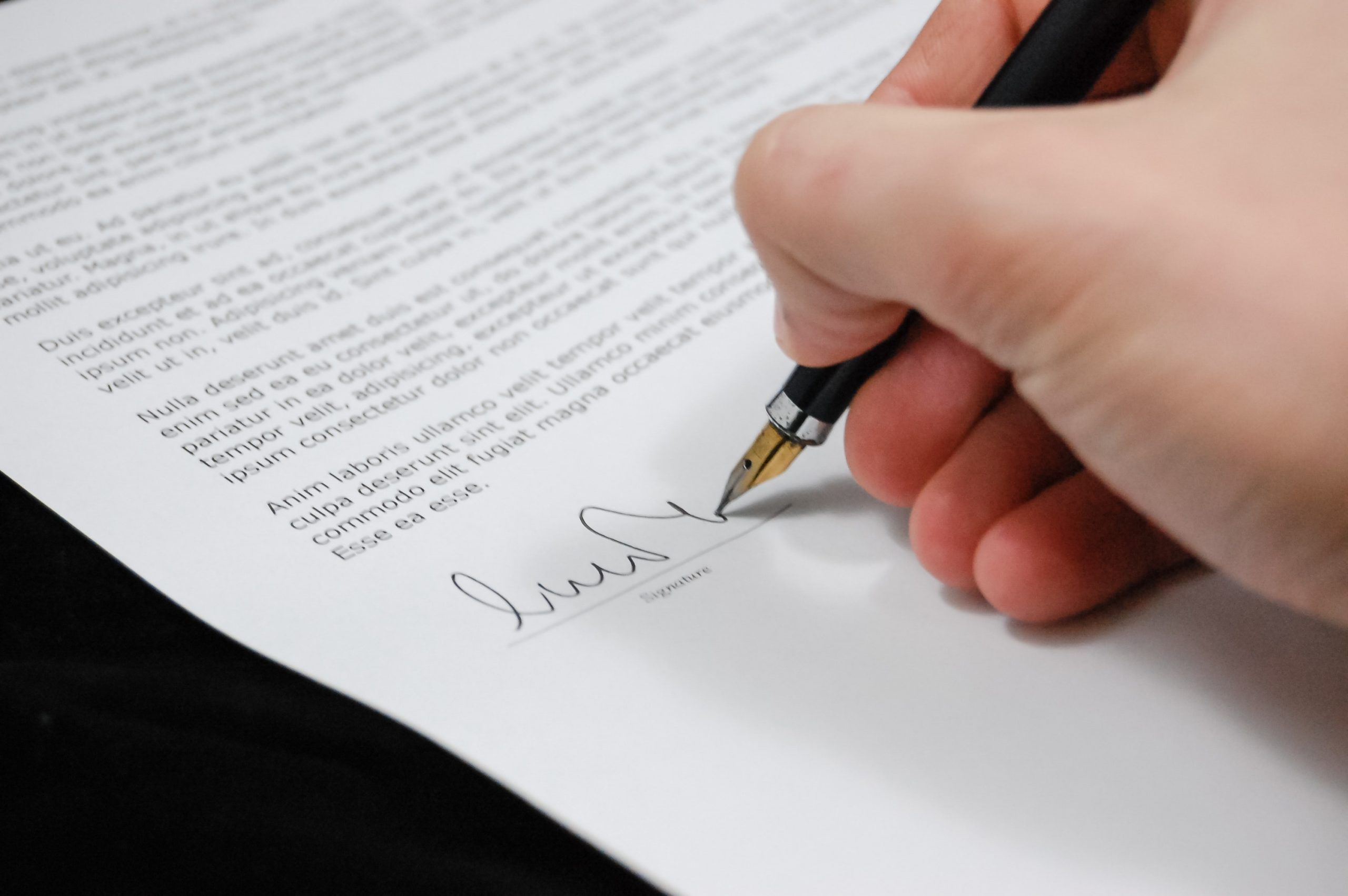 close up of signing a document
